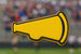 Yellow megaphone shape with black outline on a blurred sports event background from a 3.5 inch Megaphone Metal Cookie Cutter