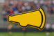 Yellow megaphone shape with black outline on a blurred sports event background from a 3.5 inch Megaphone Metal Cookie Cutter
