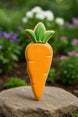 Carrot-shaped cookie with green leaf on a rock with a garden background from a 5 inch Carrot Metal Cookie Cutter