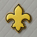 Yellow and black fleur-de-lis design on a gray quilted background from a 4.5 inch Fleur de Lis Metal Cookie Cutter