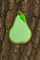 Green pear-shaped cookie on a tree trunk from a 3.25 inch Pear Metal Cookie Cutter