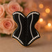 Decorative cookie shaped like a corset with pink roses in the background from a 4 inch Corset or Bathing Suit Metal Cookie Cutter