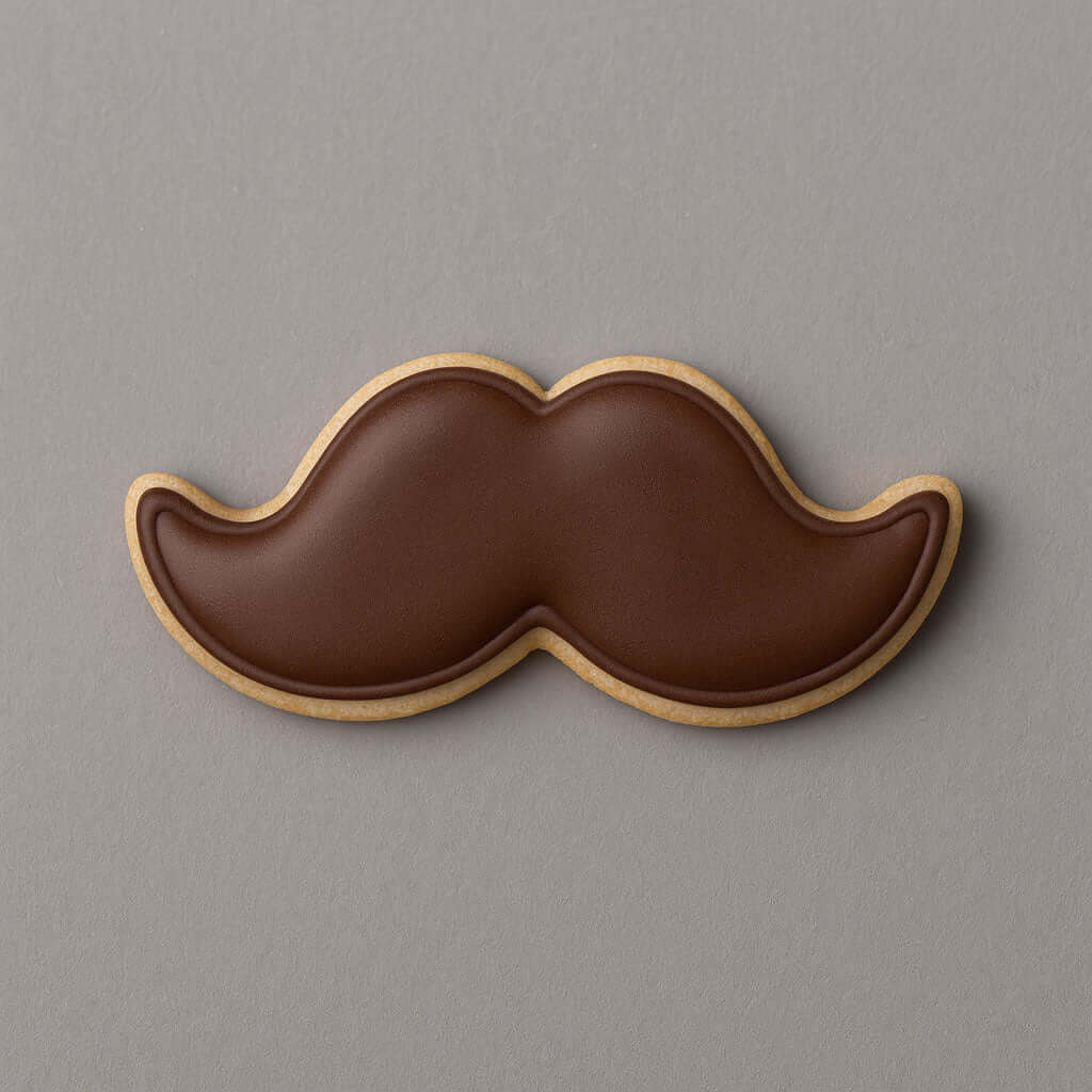 Cookie shaped like a mustache on a gray background from a 5 inch Mustache Metal Cookie Cutter