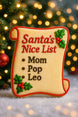 Decorative cookie shaped like a 'Santa's Nice List' with names on a festive background from a 2 inch Mini Naughty Nice Scroll Diploma Metal Cookie Cutter