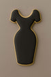 Black dress-shaped cookie with gold trim on a brown background from a 4 inch Dress Metal Cookie Cutter