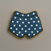 Cookie shaped like underwear with blue polka dot pattern on a beige background from a 3.5 inch Shorts or Swim Trunks Metal Cookie Cutter