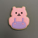 Pink bear-shaped backpack cookie with a purple round base on a gray background from a 3.5 inch School Backpack Metal Cookie Cutter