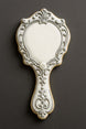 Decorative cookie shaped like a hand mirror on a dark background from a 4.5 inch Hand Mirror Metal Cookie Cutter