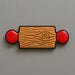 Wooden-patterned rolling pin with red circular ends on a gray background from a 5 inch Rolling Pin Metal Cookie Cutter
