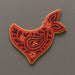 Decorative red cookie with black and gold patterns on a gray background from a 4 inch Bandana Metal Cookie Cutter