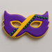 Cookie decorated like a Mardi Gras mask with purple, yellow, and green icing on a light gray background from a 4 inch Mardi Gras Mask Metal Cookie Cutter