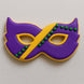 Cookie decorated like a Mardi Gras mask with purple, yellow, and green icing on a light gray background from a 4 inch Mardi Gras Mask Metal Cookie Cutter