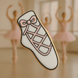 Cookie with a design of a ballet shoe and pink bow, set against a blurred background of ballerinas from a4 inch Ballet Slipper Metal Cookie Cutter
