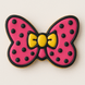 Cookie shaped like a pink bow with black polka dots and a yellow center on a light background for a 4 inch Hair Bow Metal Cookie Cutter