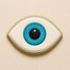 Illustration of a stylized eye with a blue iris on a beige background from a 5.5 inch Eye or Football Metal Cookie Cutter
