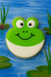 Decorative cookie shaped like a frog on a painted pond background from a 2.25 inch Frog Metal Cookie Cutter