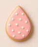 Decorated cookie shaped like a teardrop with pink icing and white pearls on a light background from a 2 inch Tear Drop Rain Flower Petal Metal Cookie Cutter