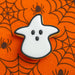 3.25 inch Candy Corn Witch Metal Cookie Cutter on an orange spider web background, perfect for Halloween baking.