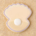 Clam shell with pearl  outlined in purple cookie on a sandy background from a 4 inch Oyster Clam Shell Metal Cookie Cutter
