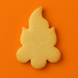 Campfire-shaped cookie on an orange background from a 3.5 inch Campfire Metal Cookie Cutter