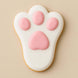 Cookie shaped like a bunny paw with pink pads on a beige background from a 2 inch Mini Bunny Rabbit Foot Metal Cookie Cutter