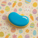 Blue and yellow jellybean on a colorful Easter-themed background from a 3.5 inch Jellybean Metal Cookie Cutter