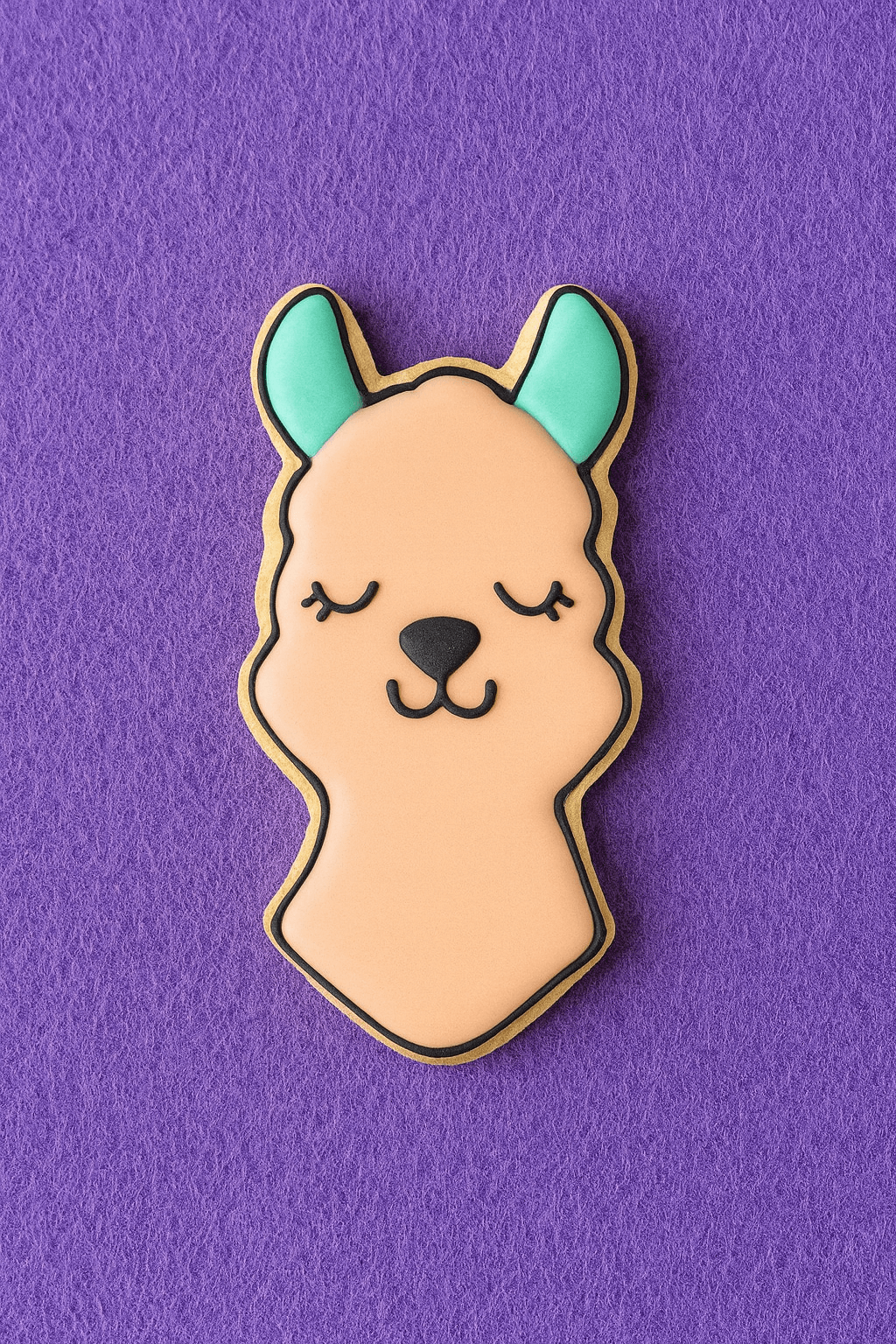 Cookie-shaped pin with a llama design on a purple background from a 2.25 inch Mini Llama Head Metal Cookie Cutter
