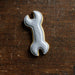 Cookie shaped like a wrench on a wooden surface from a 2 inch Mini Wrench Metal Cookie Cutter