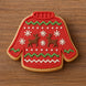 Red sweater-shaped cookie with reindeer and snowflake decorations on a wooden surface from a 2 inch Mini Ugly Sweater Metal Cookie Cutter