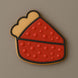 Cookie with red and yellow design on a brown background from our 2 Inch Mini Slice of Pie Metal Cookie Cutter
