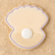 Cookie shaped like a seashell with a pearl on a sandy background from a 2 inch Mini Oyster Clam Shell with Pearl Metal Cookie Cutter