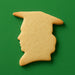 Cookie shaped like a graduation girl on a green background from a 3.75 inch Graduation Girl Metal Cookie Cutter