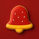 Red and yellow bell-shaped cookie on a red background from a 2.25 inch Bell Metal Cookie Cutter