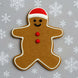 Gingerbread man cookie with a red hat and buttons on a gray background with snowflakes from a 5 inch Gingerbread Boy Metal Cookie Cutter