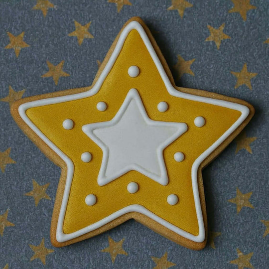 Star-shaped cookie with yellow exterior and white center on a star-patterned background from a 2.5 inch Star Metal Cookie Cutter