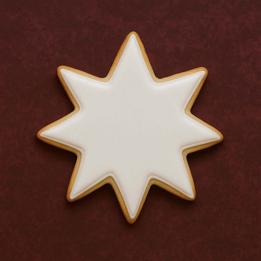 Star-shaped cookie with white icing on a dark red background from a 3.5 inch Star of Bethlehem Moravian Star Metal Cookie Cutter