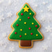 Christmas tree-shaped cookie with green icing, red and yellow decorations on a snowy background from a 3.5 inch Christmas Tree Metal Cookie Cutter