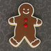 Gingerbread man cookie with red buttons on a dark patterned background from a 5 inch Gingerbread Boy Metal Cookie Cutter