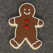 Gingerbread man cookie with red buttons on a dark patterned background from a 5 inch Gingerbread Boy Metal Cookie Cutter