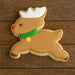 Reindeer-shaped cookie with brown body, white antlers, green nose, and red and yellow accents on a wooden surface from a 3 inch Reindeer Metal Cookie Cutter