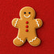 Gingerbread man cookie with a smile on a red background from a 3.5 inch Folk Gingerbread Boy Metal Cookie Cutter