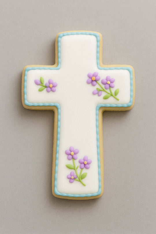 Decorative cross-shaped cookie with floral designs on a gray background from a 4 inch Cross Metal Cookie Cutter