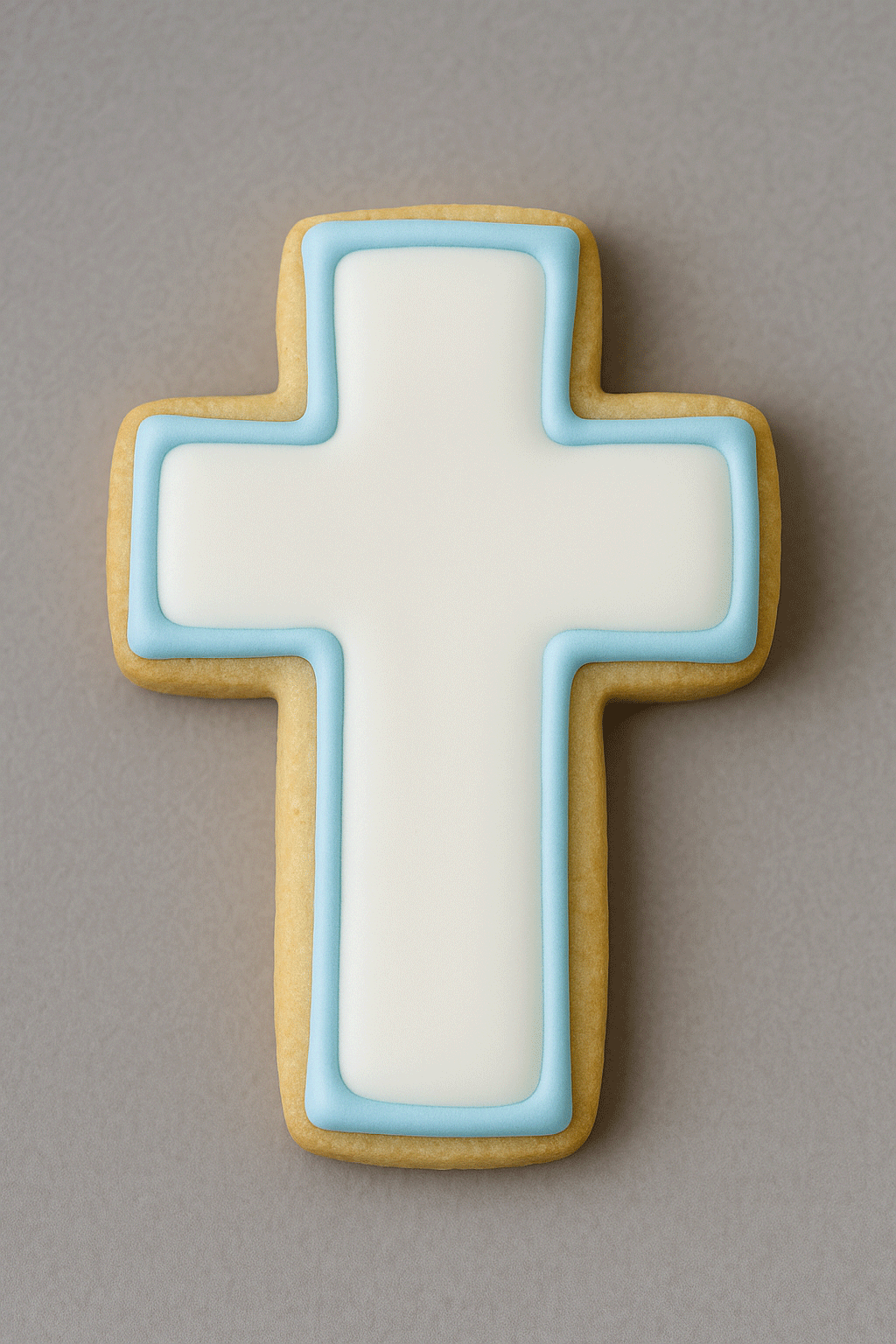 2.75 inch Cross Metal Cookie Cutter shaped cookie with blue icing against a gray background.