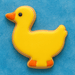 3 inch Duck Metal Cookie Cutter shaped sugar cookie decorated in bright yellow with orange accents on a blue background.