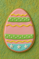 4 inch Easter Egg Metal Cookie Cutter shaped cookie decorated with pink, green, and yellow icing for Easter.