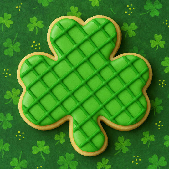 Green plaid shamrock cookie on a green background with shamrock patterns from a 3 inch Shamrock Metal Cookie Cutter