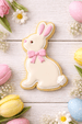 5 inch Chocolate Easter Bunny Rabbit Metal Cookie Cutter shaped cookie decorated with icing and surrounded by flowers.