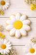 3.5 inch Daisy Flower Metal Cookie Cutter shaped cookie decorated with white icing and yellow sprinkles, surrounded by daisies.