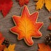 Maple leaf-shaped cookie on a bed of autumn leaves from a 3 inch Maple Leaf Metal Cookie Cutter
