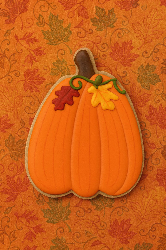 Decorative pumpkin-shaped cookie on an autumn-themed background with leaves.